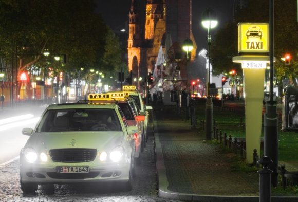 Ein Taxistand in Berlin mit wartenden Taxis in der Nacht