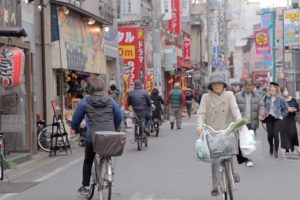Eine Japanerin transportiert mit dem Fahrrad ihre Einkäufe nach Hause