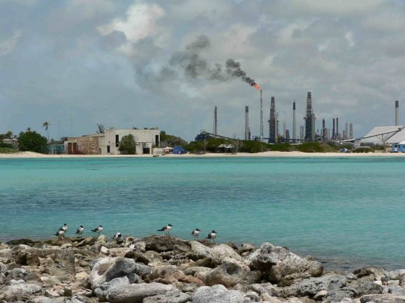 Valero Ölraffiniere von einem Karibikstrand aus fotografiert Kontrast Energieerzeugung Tourismus