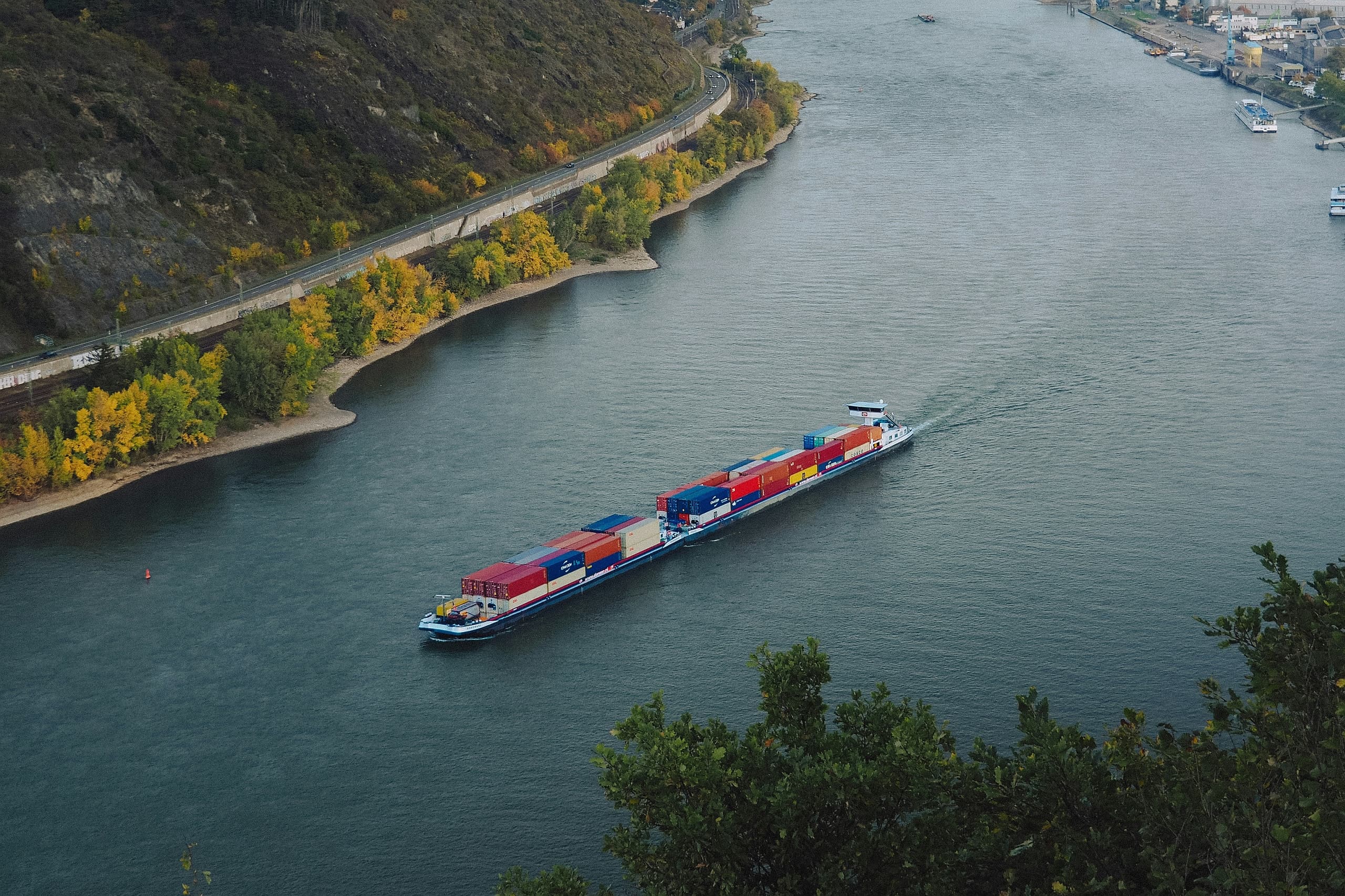 Ein Container-Binnenschiff fährt auf dem Rhein bei Andernach in einer Kurve